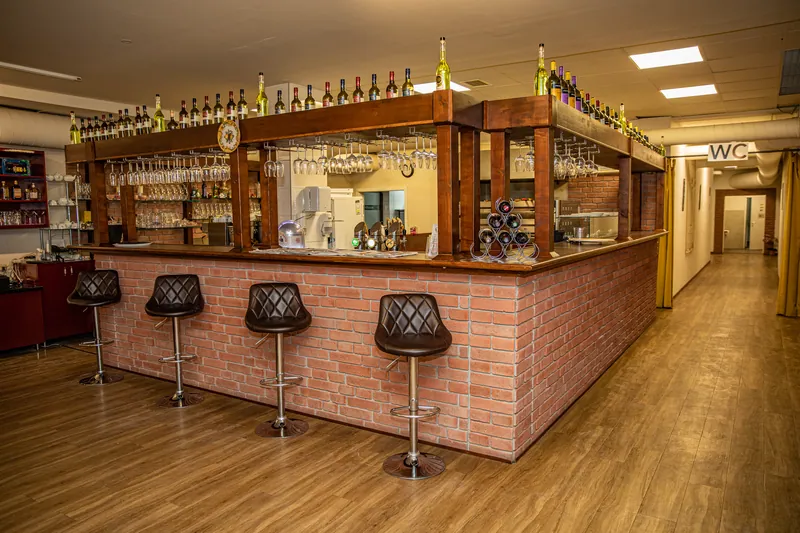 Bar sa drvenim šankom i barskim stolicama, fotografija ugostiteljskog prostora